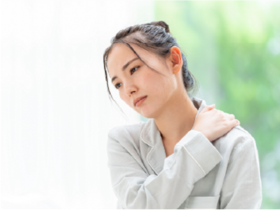 肩こりに悩み肩に手を当てている女性