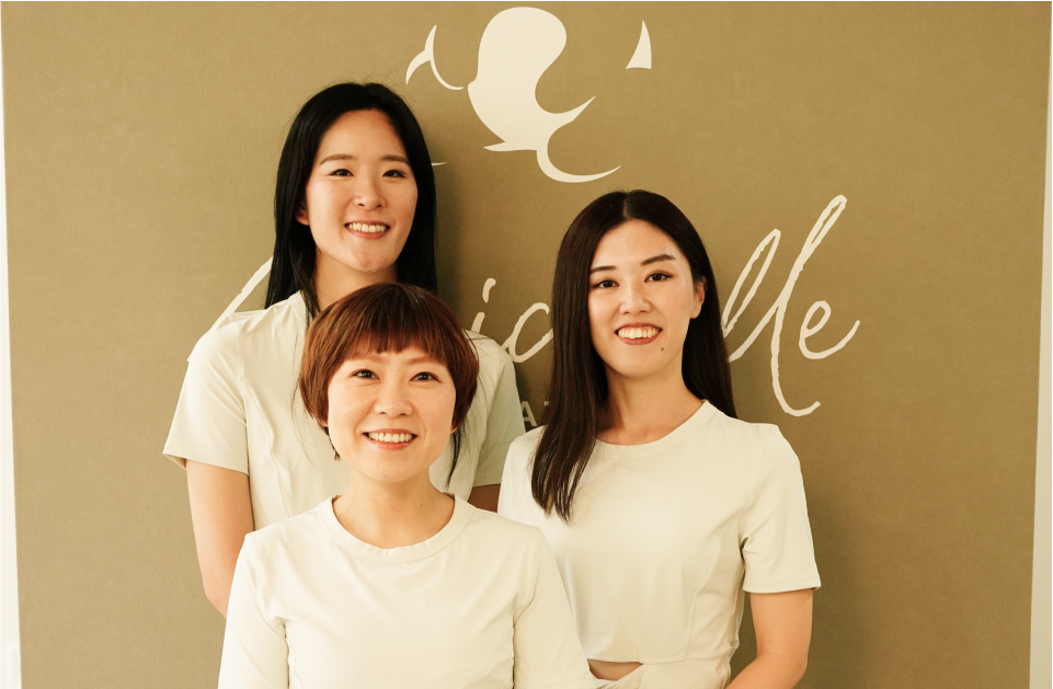 ピラティススタジオの女性インストラクター3名が笑顔で並ぶ集合写真